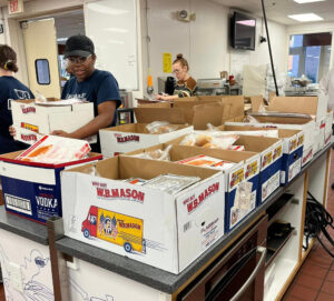 A bunch of people packing boxes inside a facility